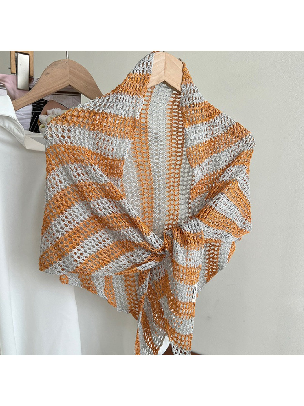 Scarvii open knit scarf draped over chair showcasing triangle shape