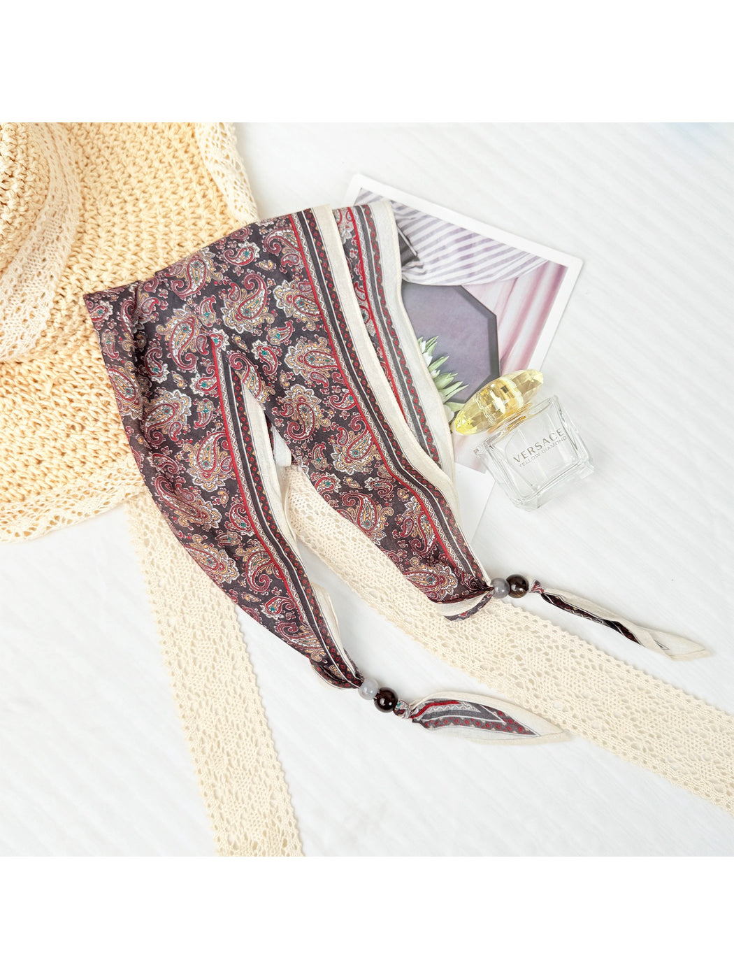 Scarvii triangle scarf laid flat highlighting paisley print and bead accents