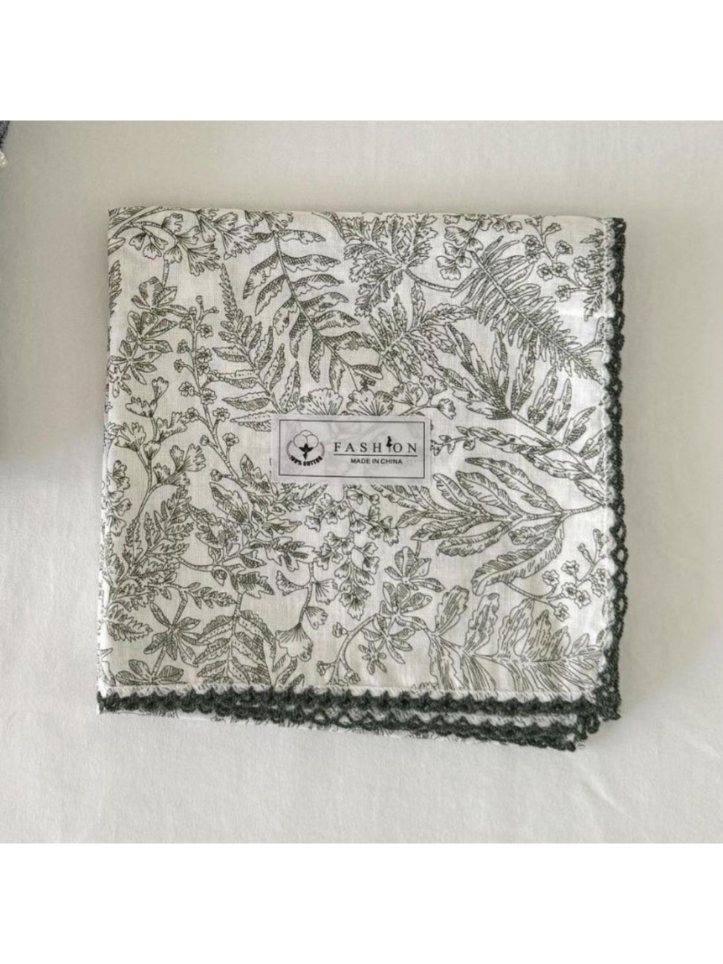 Scarvii scarf partially folded showing layered botanical patterns and smooth fabric finish