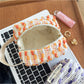 Cosbai woven stripe cosmetic bag with colorful horizontal stripes on a plain background