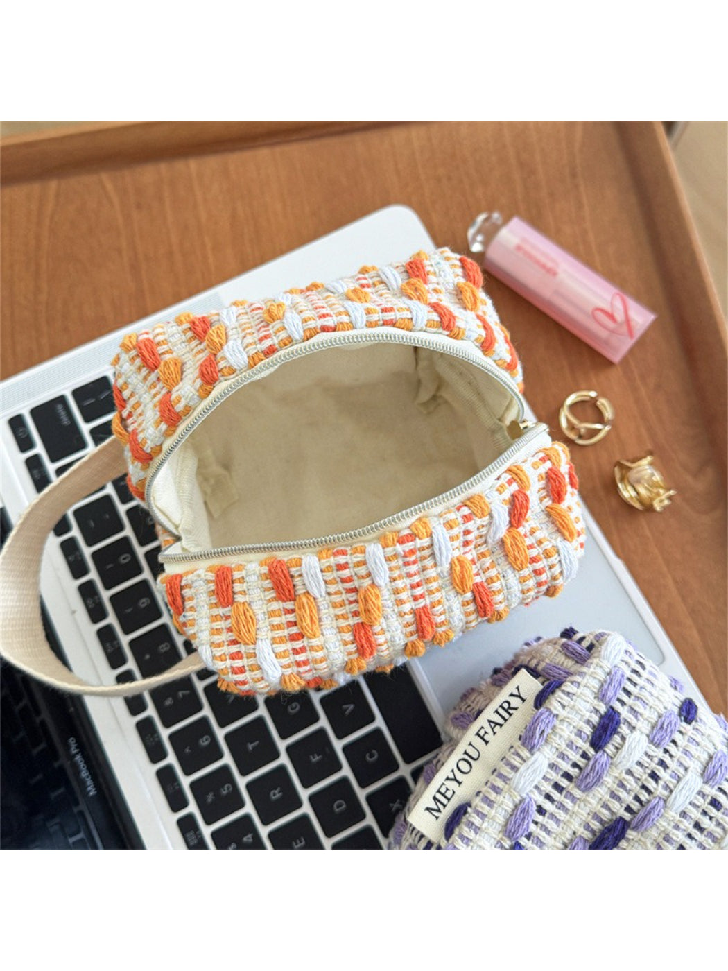 Cosbai woven stripe cosmetic bag with colorful horizontal stripes on a plain background