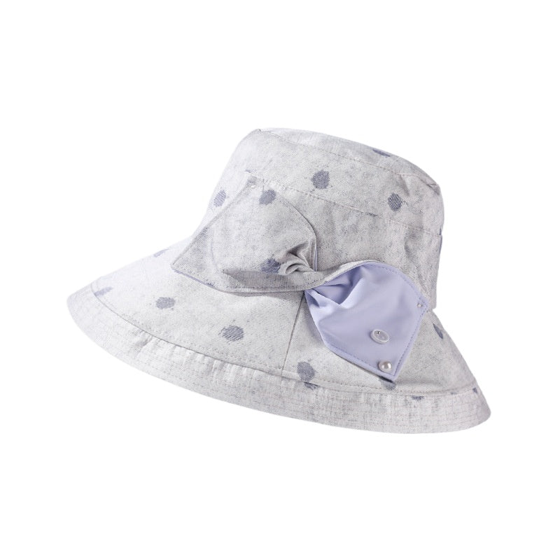 Haila polka dot bow brim hat hanging on a hook against plain wall