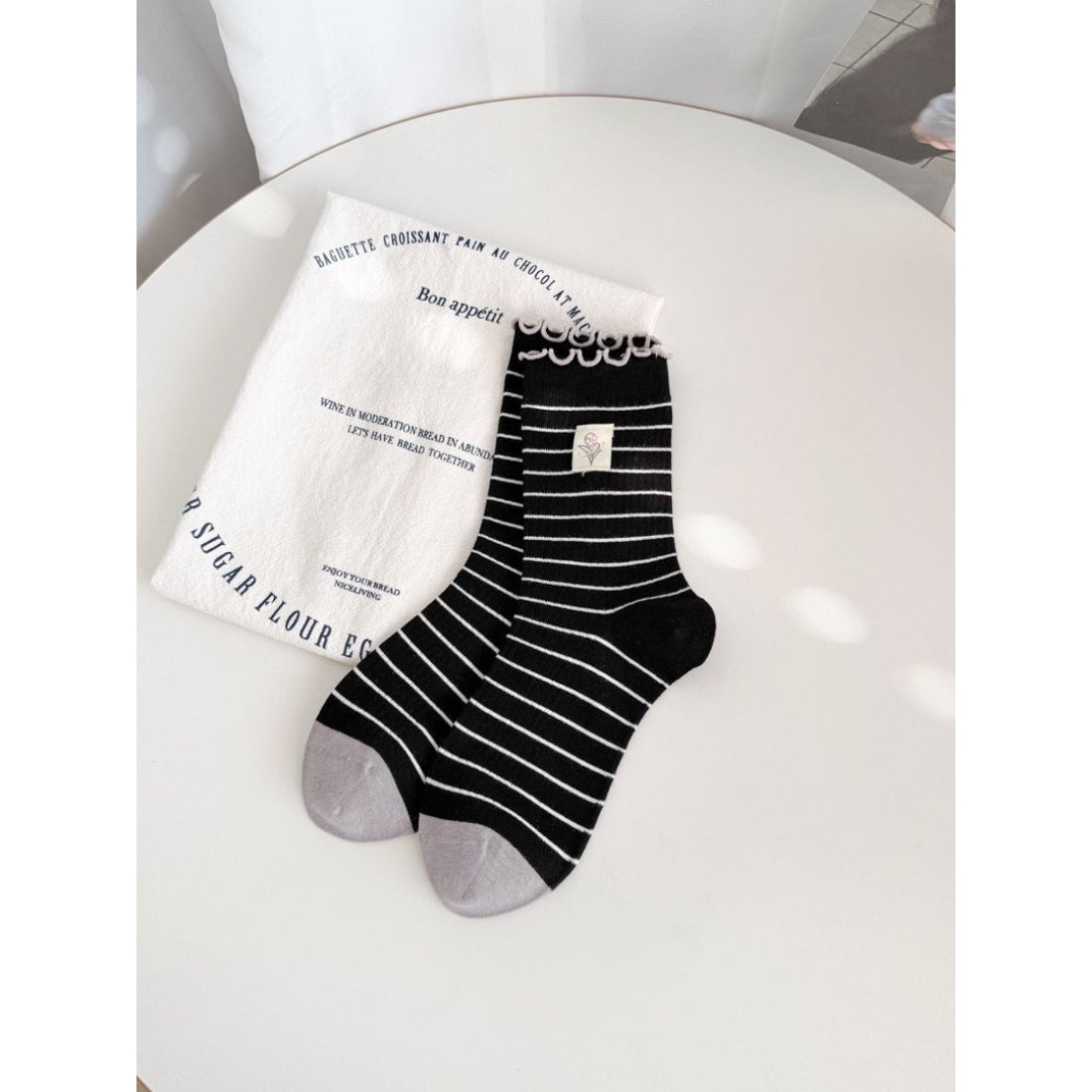 Rufia Lettuce Edge Stripe Crew Socks worn on feet with black and white stripes