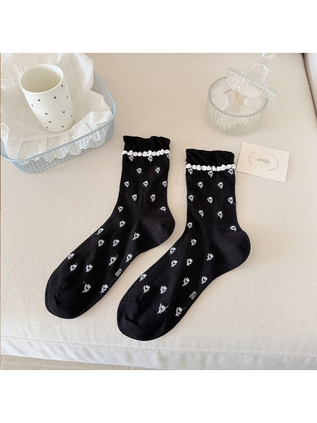 Close-up of pom pom trim detail on Rufia floral crew socks cuff