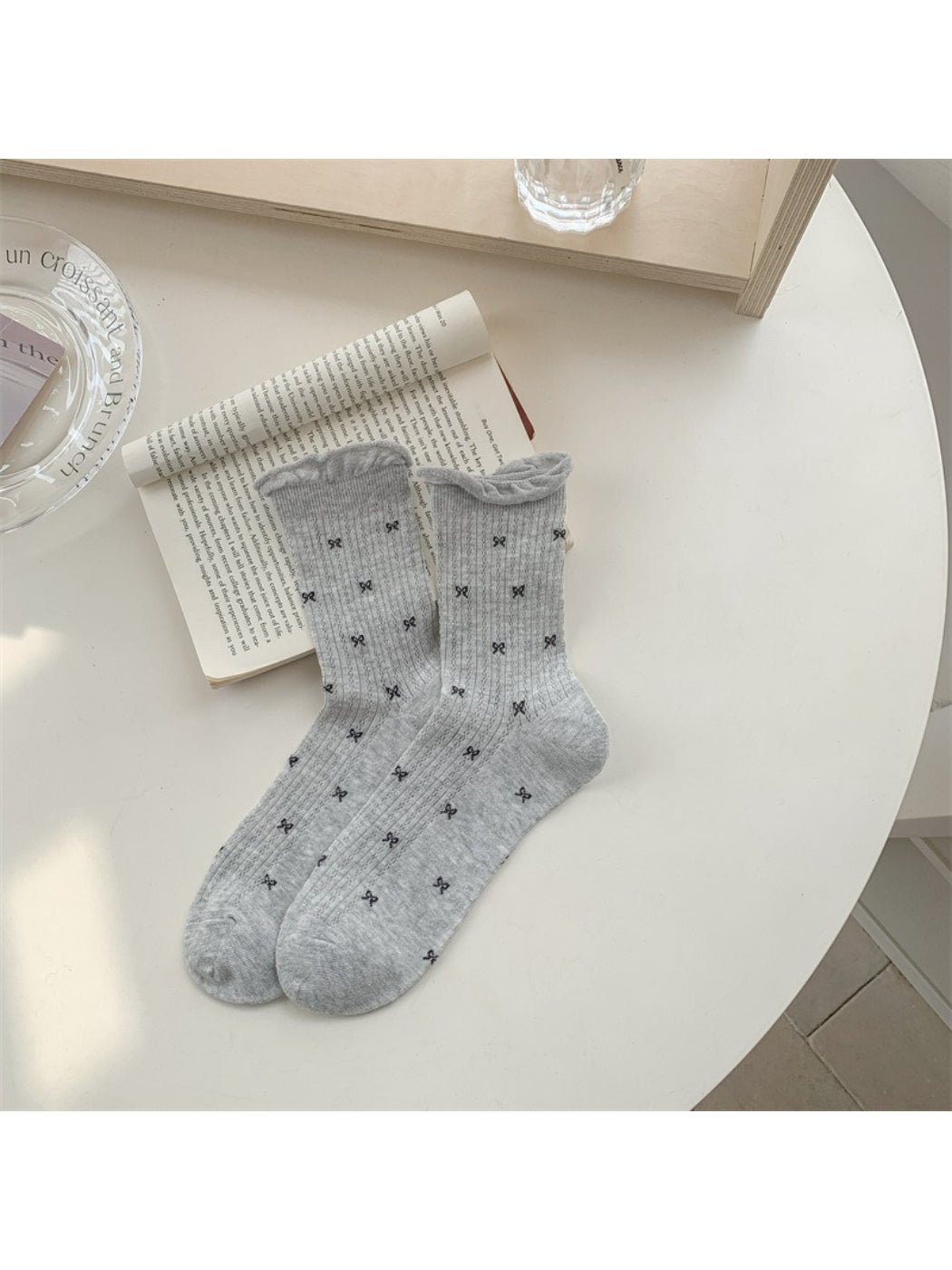 Stack of Rufia vintage style crew socks with tiny flower motifs in various colors