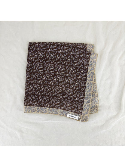 Scarvii scarf styled around neck with ditsy floral border visible