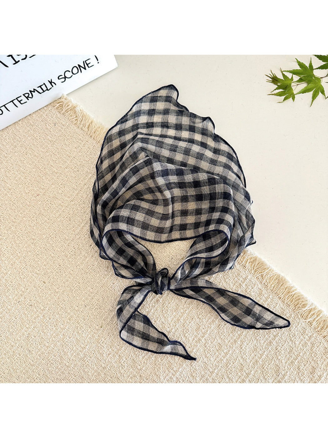 Model wearing classic check tie head scarf styled around the head