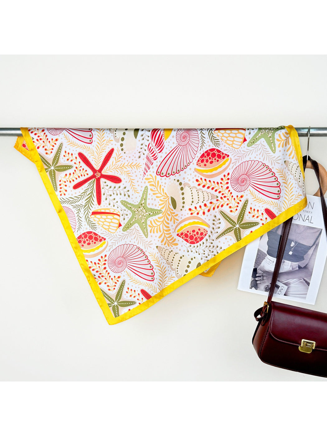 Scarvii scarf folded in a triangle highlighting the blue and white seaside motifs