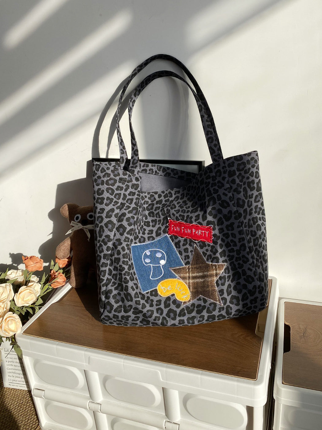 Cosbai leopard print carry bag held by model wearing casual streetwear