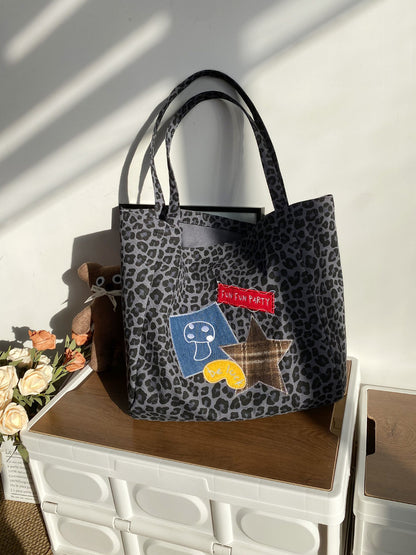 Cosbai leopard print carry bag held by model wearing casual streetwear