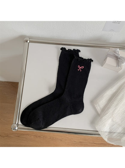 Side view of Rufia crew sock featuring delicate bow and wavy lettuce edge