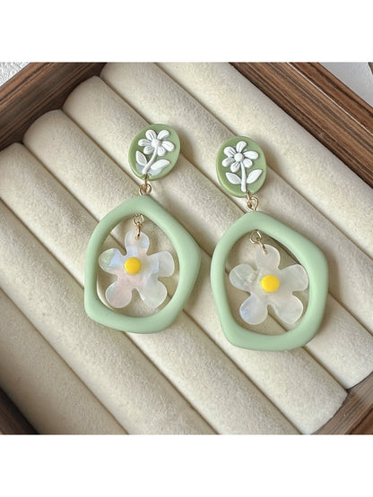 Pair of green daisy hoop earrings displayed on a white background