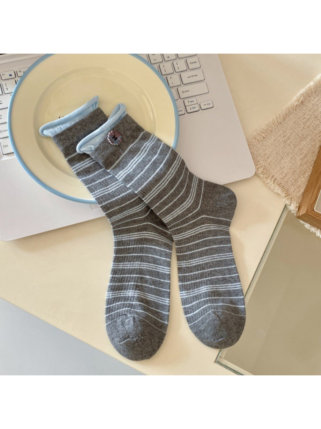 Rufia ribbed socks with buttons folded neatly on wooden surface