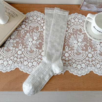 Model wearing Rufia beige ribbed crew socks with rolled-up pants