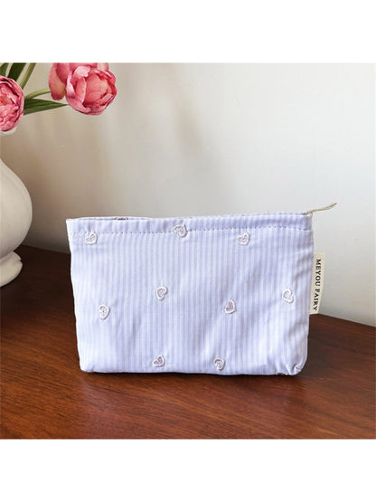 Cosbai makeup organizer bag with heart pattern placed on a vanity table