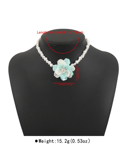 White beaded flower necklace draped over a wooden surface showcasing craftsmanship