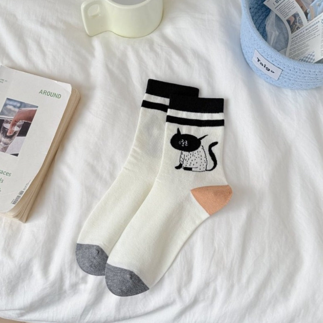 Pair of Rufia cat knit crew socks displayed on wooden surface