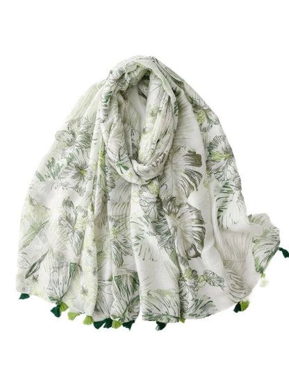 Model wearing Scarvii Tropical Floral Tassel Scarf styled around the neck outdoors