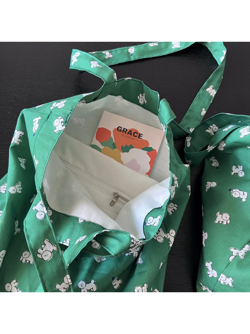 Close-up of green tote bag fabric texture and puppy design