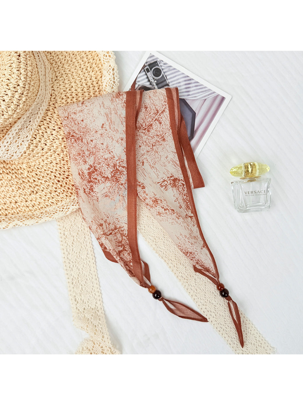 Folded sheer triangle scarf highlighting the vibrant print and beadwork