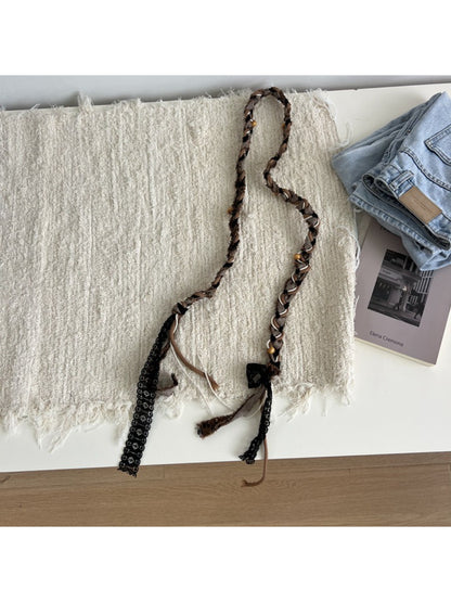Beco braided fabric belt coiled to display texture and tassel ends