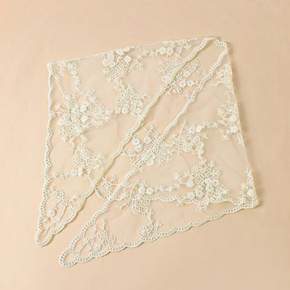 Model adjusting Haila floral lace veil head scarf in natural outdoor setting
