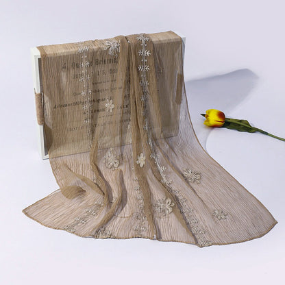 Scarvii scarf wrapped around neck with visible blossom stitch floral pattern