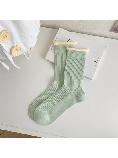Side view of Rufia ribbed crew socks highlighting pastel orange contrast trim