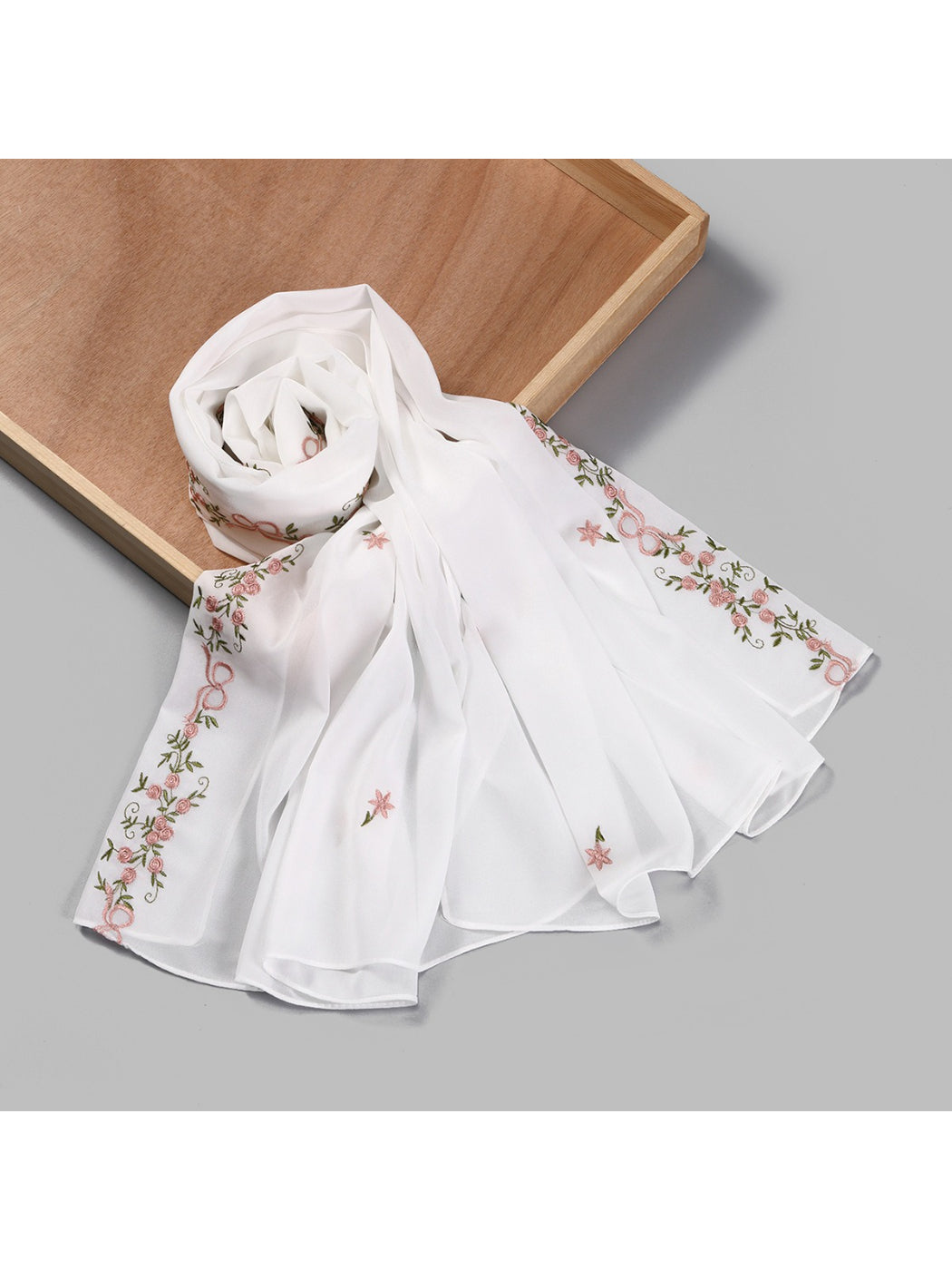 Soft botanical embroidered scarf folded on a white background