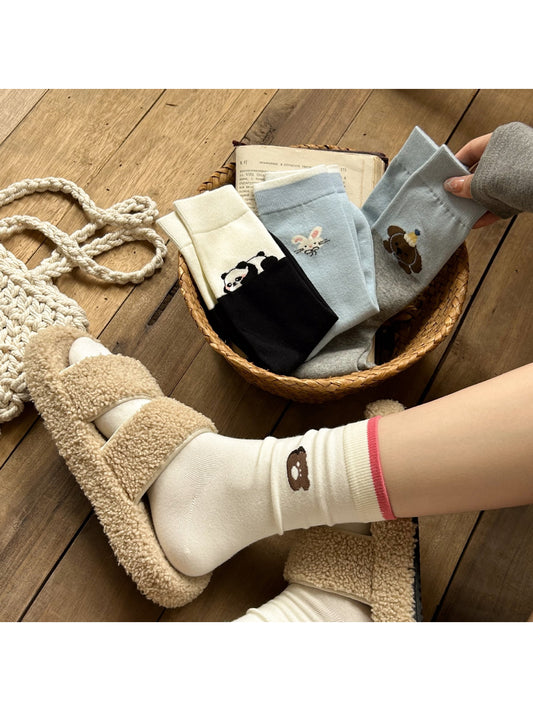 Pair of Rufia soft crew socks with a brown bear animal motif on a cream background