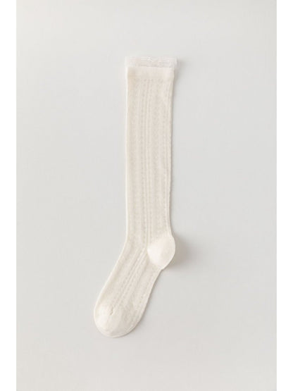 Rufia soft cable knee high socks styled with skirt and boots on model