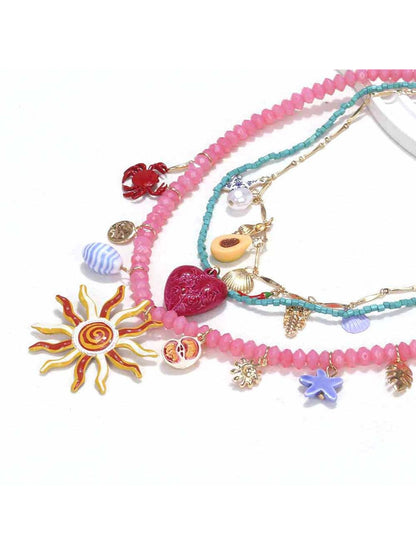 Side view of Neckit layered charm necklace highlighting sun and heart charms