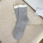 Pair of Rufia ribbed crew socks in white with delicate ruffle trim
