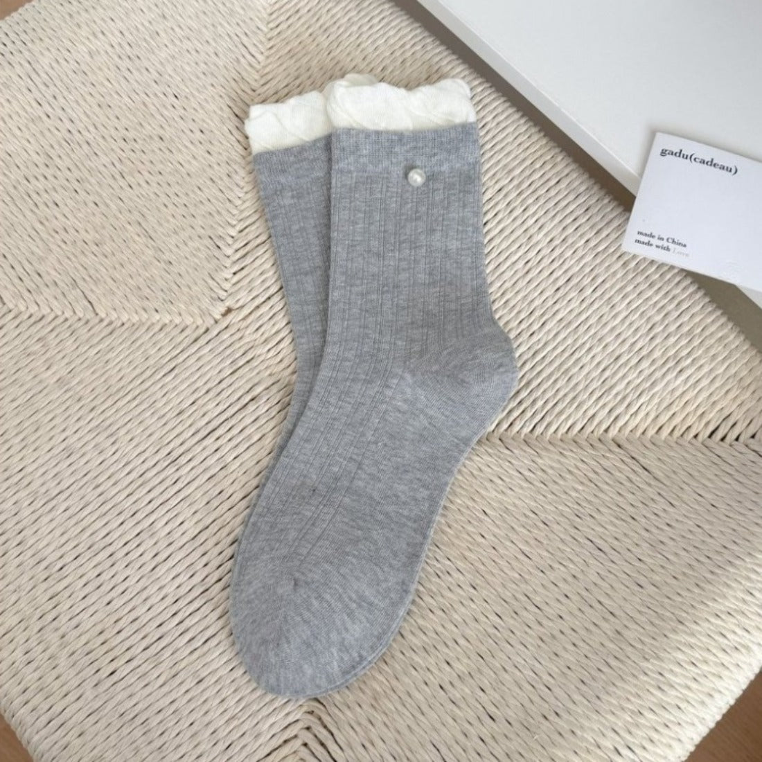 Pair of Rufia ribbed crew socks in white with delicate ruffle trim