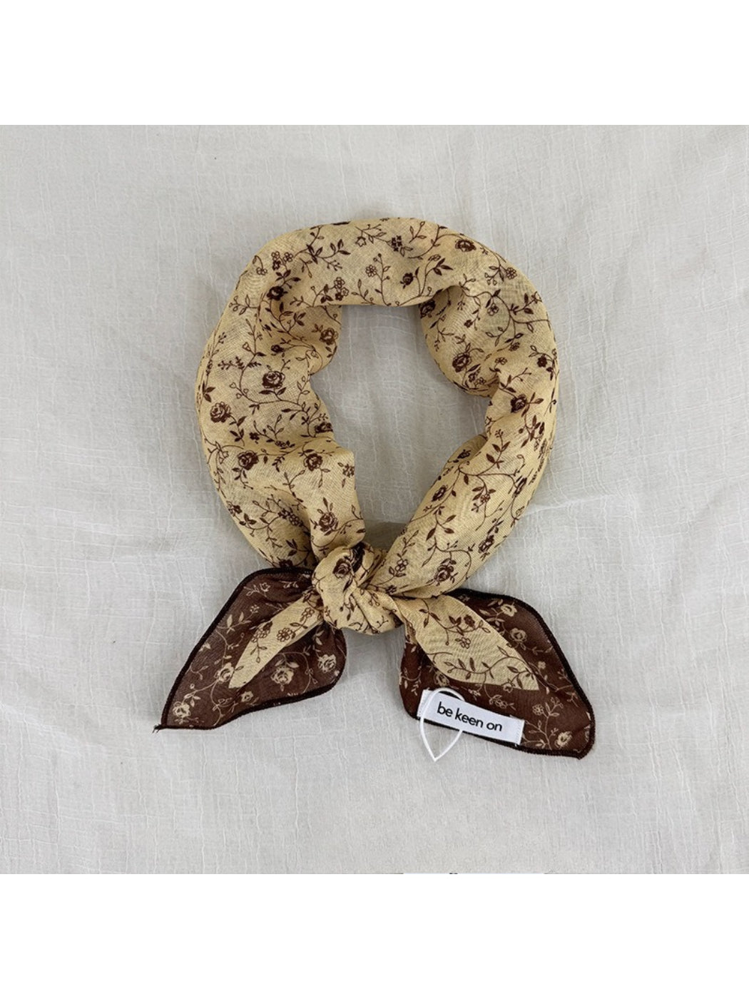 Model wearing Scarvii Vintage Botanical square scarf styled around the neck with floral pattern