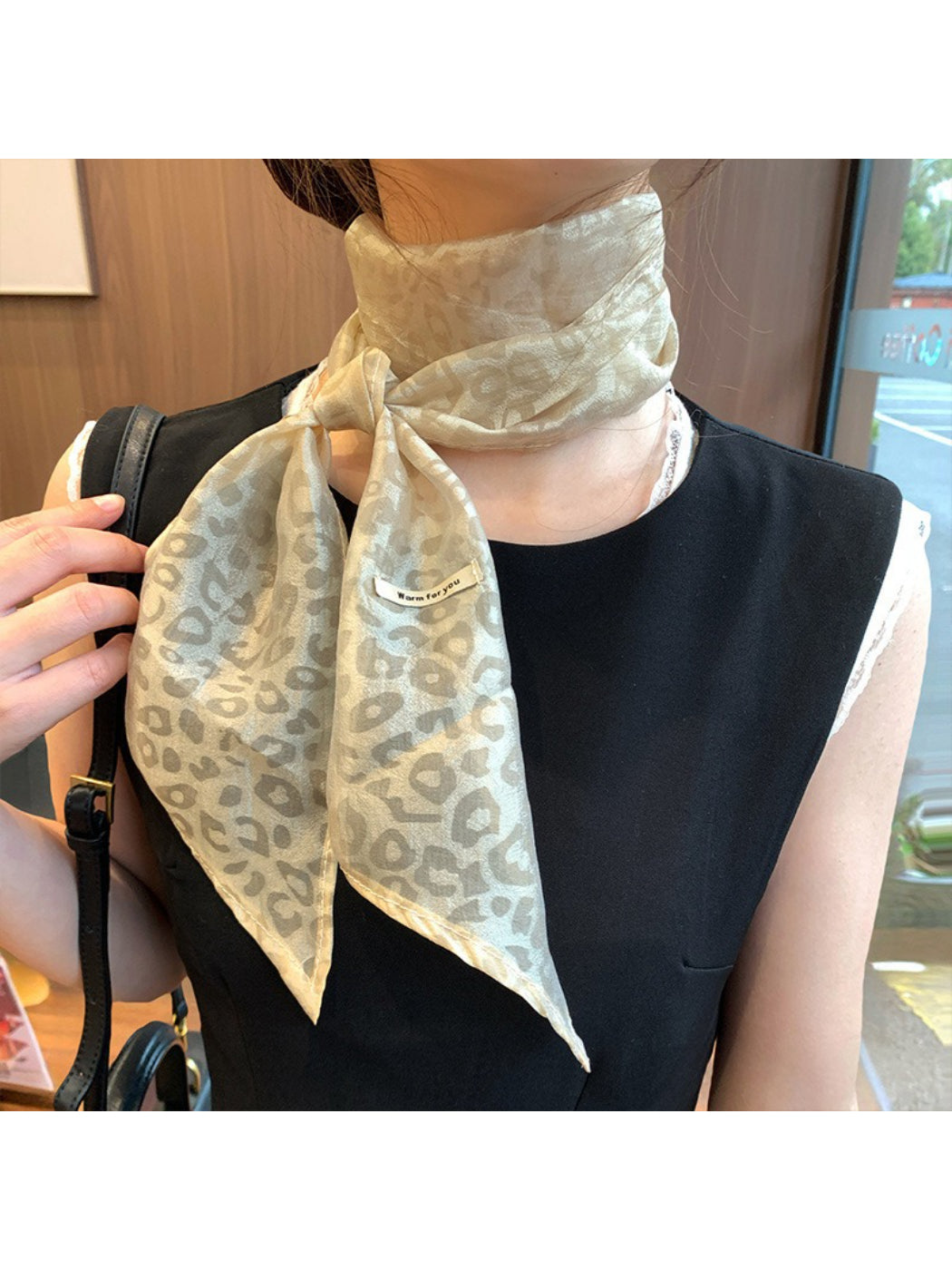 Close-up of leopard print pattern on sheer fabric neck scarf