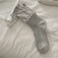 Side view of Rufia Ribbon Ruffle Crew Socks emphasizing ribbon ruffle around cuff