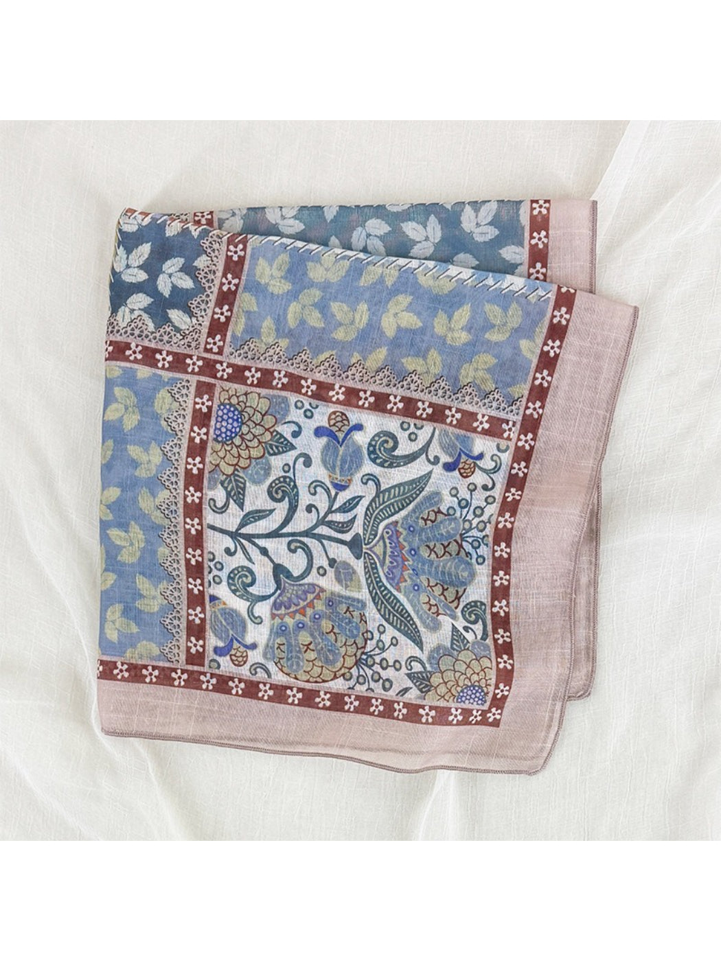 Scarvii scarf draped over shoulder showing vibrant floral and geometric patchwork design