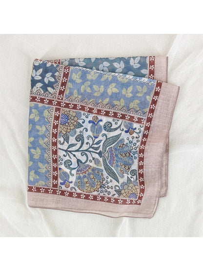 Scarvii scarf draped over shoulder showing vibrant floral and geometric patchwork design