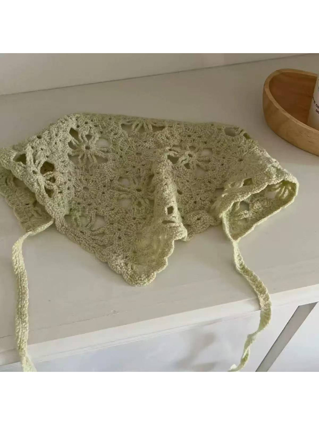 Boho open knit scarf draped over a wooden chair