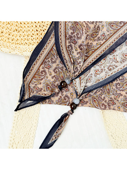 Close-up of Scarvii triangle scarf bead embellishments on paisley fabric