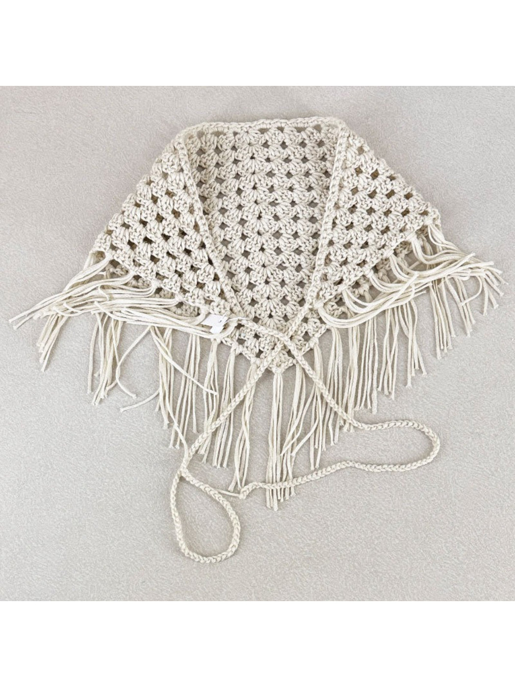 Close-up of intricate crochet pattern and tassel details on the bandana