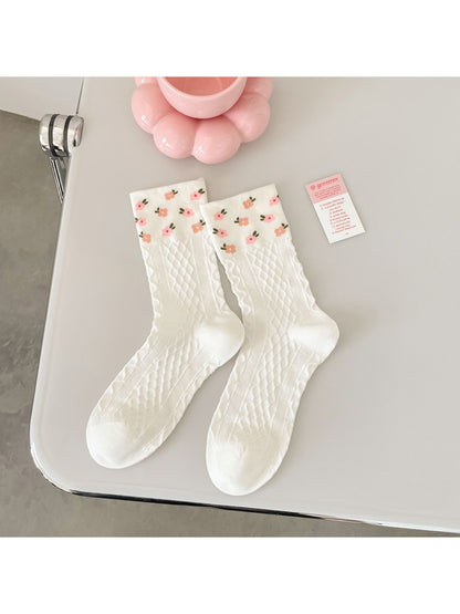 Pair of Rufia pink floral ribbed crew socks laid flat displaying full floral design