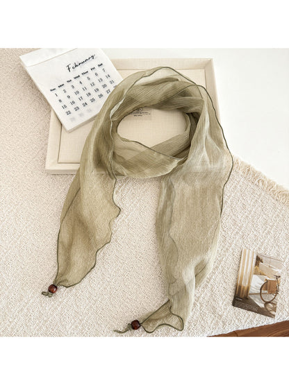 Soft pleated sheer skinny scarf folded neatly showing lightweight fabric