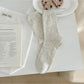 Stack of Rufia neutral textured crew socks in neutral tones folded neatly