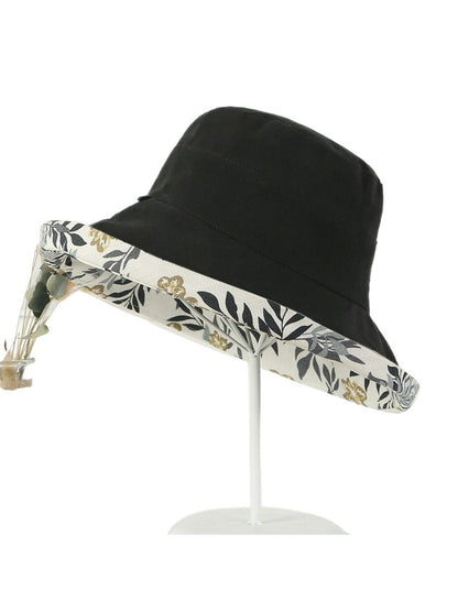 Model wearing Haila reversible floral bucket hat outdoors