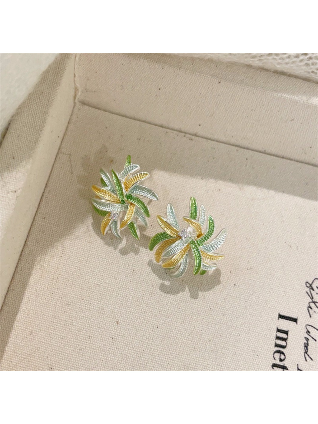 Earwish Color Burst Floral Earrings arranged with matching accessories on a wooden surface