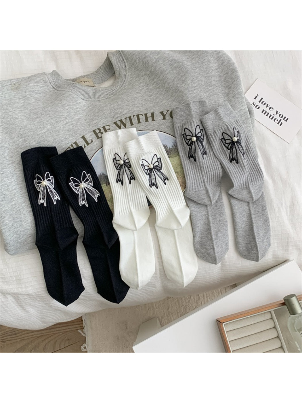 Model wearing Rufia beige crew socks with bow accent paired with casual shoes