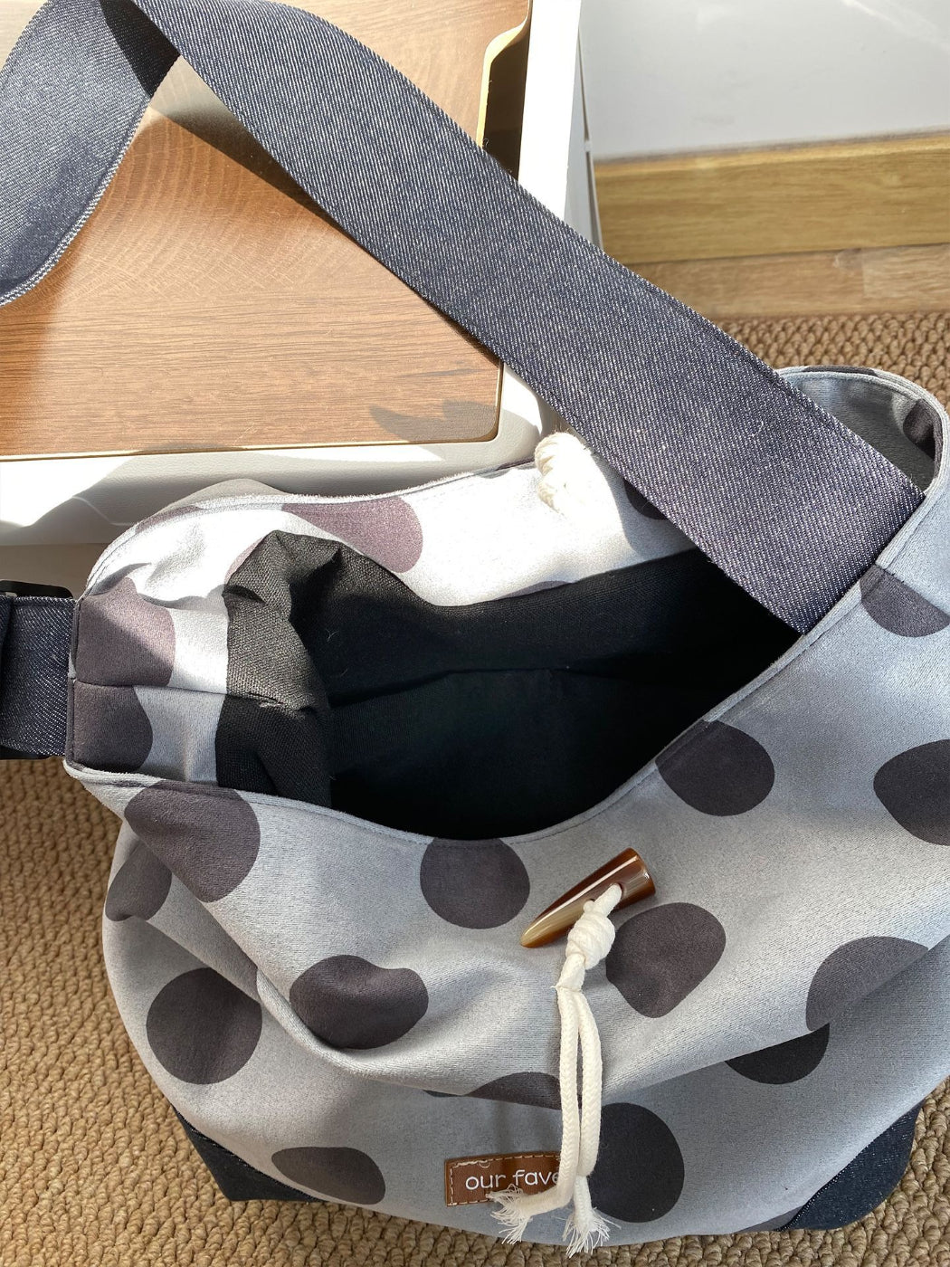 Back view of Cosbai polka dot drawstring crossbody bag highlighting smooth finish