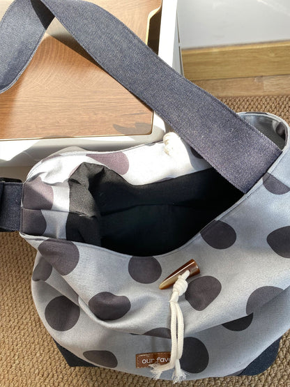 Back view of Cosbai polka dot drawstring crossbody bag highlighting smooth finish